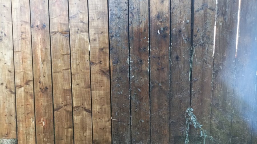 Lames de bois côte à côte, moitié nettoyée et traitée, moitié encore encrassée